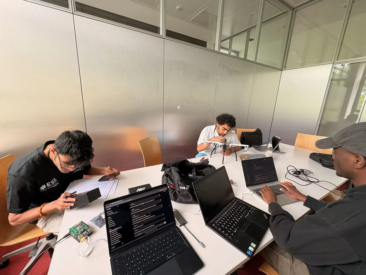 Three KERNTAKT members working together at a table with laptops.